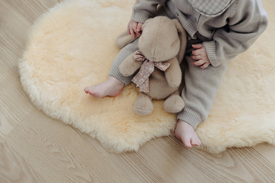 Kind sitzt auf Baby Lammfell