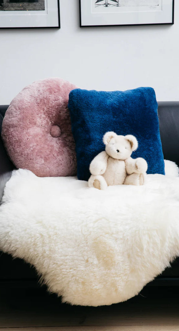 Fellkissen und ein Lammfell auf ein Sofa